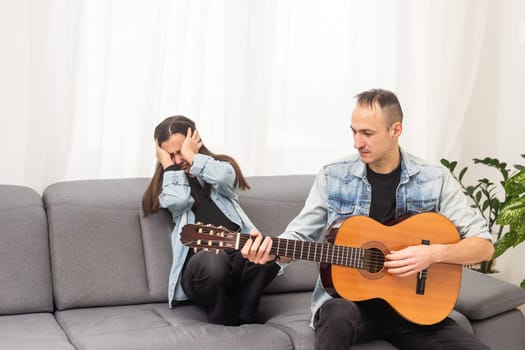 A father teaching his daughter how to play guitar. High quality photo