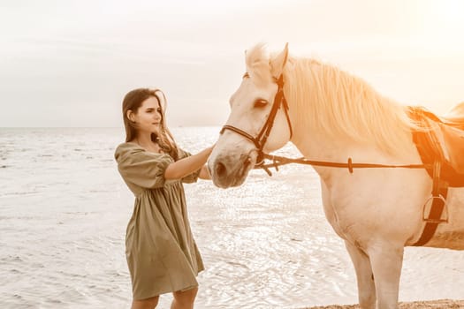 A white horse and a woman in a dress stand on a beach, with the sky and sea creating a picturesque backdrop for the scene