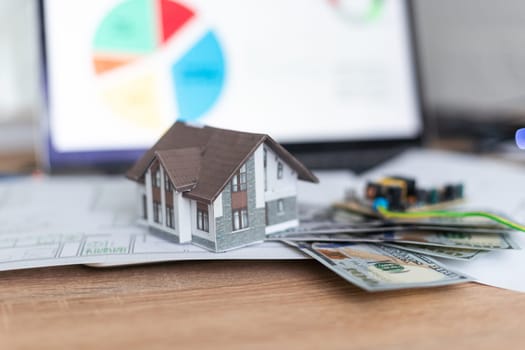 Model house on top of money pile suggesting savings for a house. High quality photo