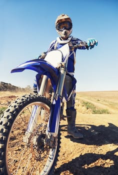 Motorbike, sports and danger with biker person outdoor, low angle with uniform for riding on dirt track. Speed, power and risk with motorcycle, transportation and adventure for adrenaline and travel.