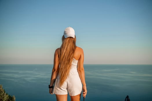 Portrait of a happy woman in a cap with long hair against the sea.