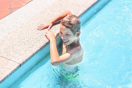Happy boy in the outdoor swimming pool.