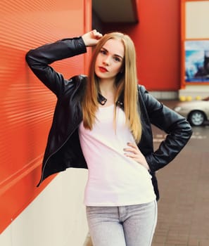 Portrait of beautiful blonde young woman wearing black leather rock style jacket in the city