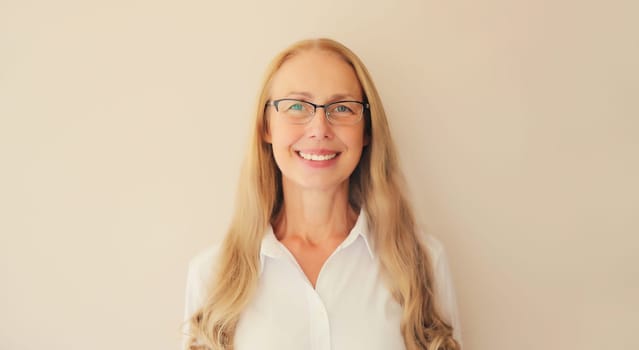 Portrait of happy smiling caucasian middle aged woman employee manager in eyeglasses and looking at camera in office at work or home