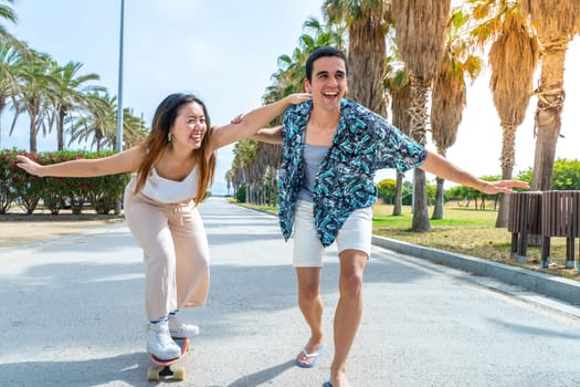 Young diverse couple with skateboard and longboard having fun outdoors. High quality photo