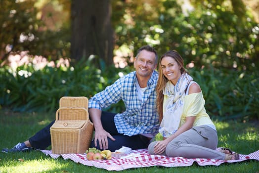 Portrait, picnic and couple with love, basket and happiness with romance and Valentines day with marriage. Date, man and woman on the ground, relationship or anniversary with celebration or honeymoon.