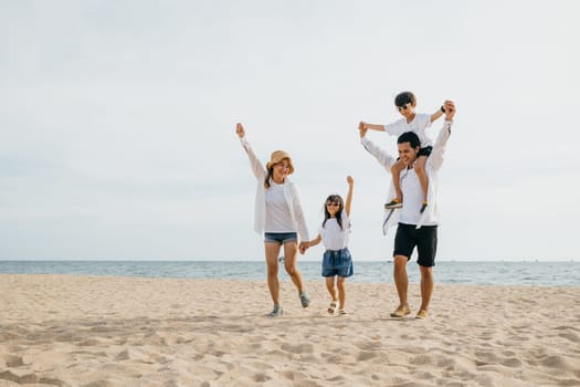 A picturesque family scene at the sunset sea beach, parents and children with raised arms expressing happiness. The father carrying his son on shoulders adds a touch of carefree summer vacation joy.