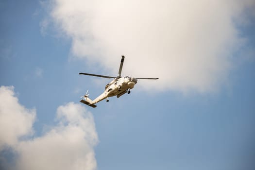 Helicopter in flight against blue sky demonstrating modern rescue and transportation technology. New engine hovering capabilities. Pilot manages small aircraft's speed and angles.