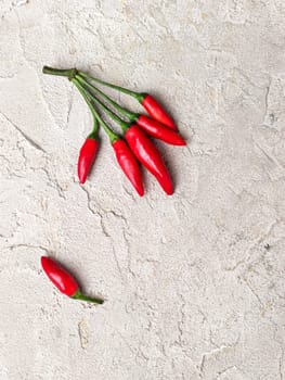 Hot red peppers on a white table, taken from above.