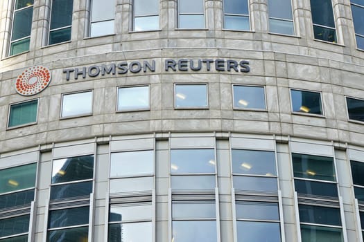 London, United Kingdom - February 03, 2019: Sun shines on Thomson Reuters offices building at Canary Wharf in UK capital. TR Group is Canadian multinational mass media and information firm