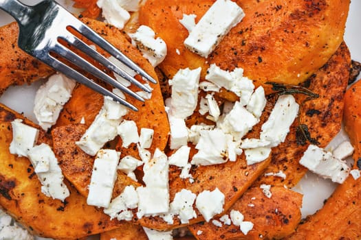 Fork over bright orange grilled butternut squash and white feta cheese