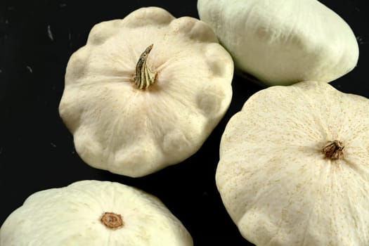 White pattypan squash heads on black table