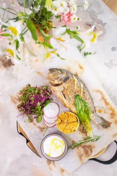 A mouthwatering dish featuring grilled fish seasoned with zesty lemon and aromatic herbs, beautifully presented on a white plate.