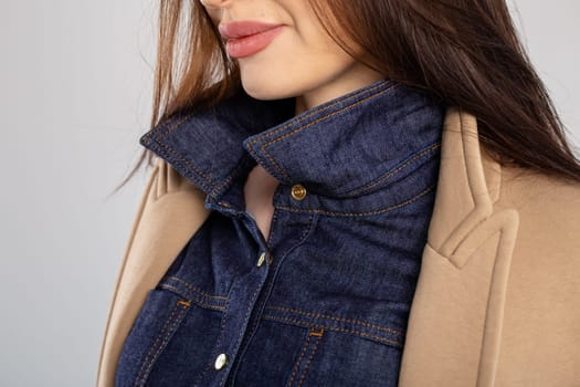 Close-up of a blue denim shirt collar with a brown corduroy jacket lapel. Shirt is buttoned up, collar turned up, and jacket open.