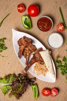 A delicious and hearty meal of grilled lamb chops, vegetables, and lavash bread. Perfect for a family dinner or a party with friends.