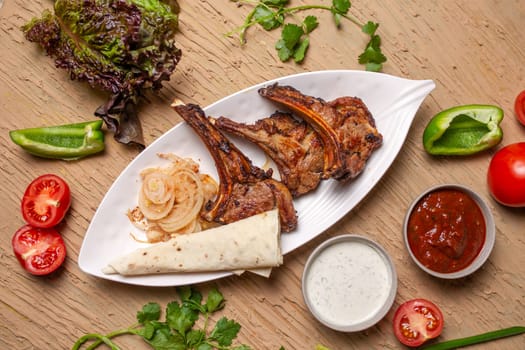 A delicious and hearty meal of grilled lamb chops, vegetables top view, and lavash bread. Perfect for a family dinner or a party with friends.