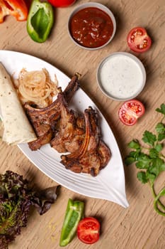 A delicious and hearty meal of grilled lamb chops, vegetables, and lavash bread. Perfect for a family dinner or a party with friends.