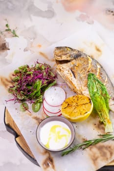 A mouthwatering dish featuring grilled Dorado fish seasoned with zesty lemon and aromatic herbs, beautifully presented on a white plate.