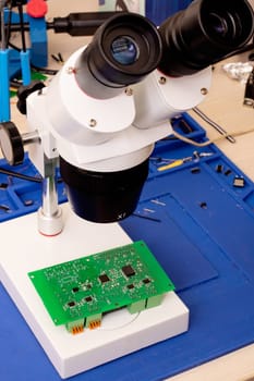 Soldering process on a green PCB close up