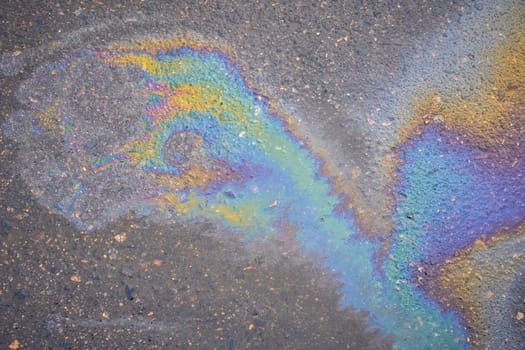 Textured stain of fuel or oil on wet asphalt on a rainy day. The concept of environmental pollution.