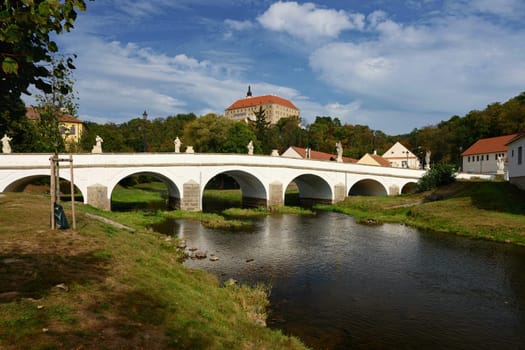 Beautiful old castle with a bridge over the river at sunset. European old architecture. Namest nad Oslavou - a city in the Czech Republic.