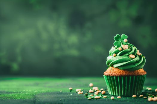 One freshly baked cupcake with green buttercream, candy sprinkles and shamrock leaves stands on the right on a green background with copy space on the left, side view close-up.