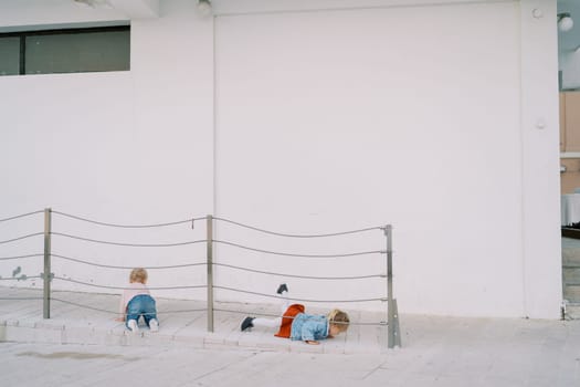 Little girls crawl on the ramp near the building. High quality photo