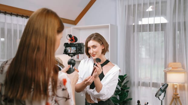 Two influencer partner shoot live streaming vlog video review makeup prim social media or blog. Happy young girl with cosmetics studio lighting for marketing recording session broadcasting online.