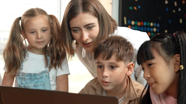 Smart teacher checking student answer while learner using laptop to doing homework, analysis data, programing engineering code and prompt, studying computer system at STEM technology class. Erudition.