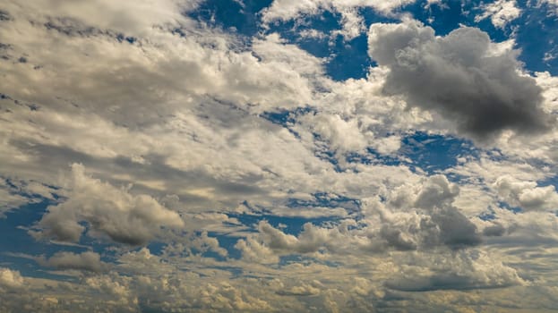 Expansive View Of A Blue Sky Filled With White Cumulus Clouds Casting Shadows On Each Other Under The Sunlight.