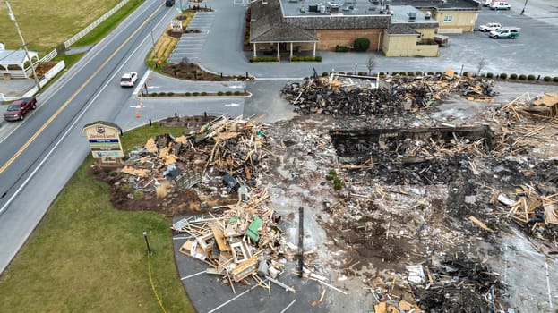 Bird in Hand, Pennsylvania, USA, September 14, 2023 - An Aerial View Of A Devastated Building Amidst Intact Structures With Cars On The Road And Green Fields In The Background Under A Cloudy Sky.