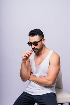 Young man with beard smoking a cigar in a studio