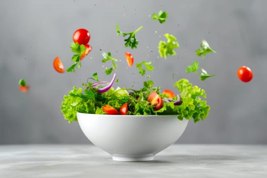 A white bowl filled with fresh lettuce leaves and vibrant red tomatoes, displayed against a neutral gray backdrop.