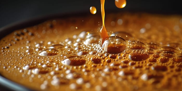 A close up, macro shot showing the bubbles and texture of a delicious, hot cup of brown coffee with a light layer of foam forming a pattern on top. Image has copy space.