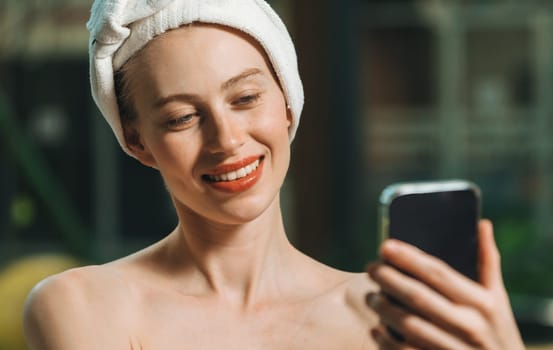 Portrait of close up beautiful caucasian woman in white towel taking video of calm and relaxing nature by using her mobile phone. Pretty girl with beautiful skin take photo. A Side view. Tranquility.