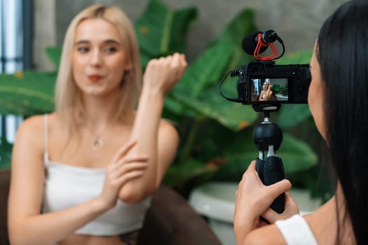 Two beautiful content creator making natural beauty and cosmetic tutorial on green plant leave garden video. Beauty blogger showing how to beauty care to social medial audience by selfie stick. Blithe