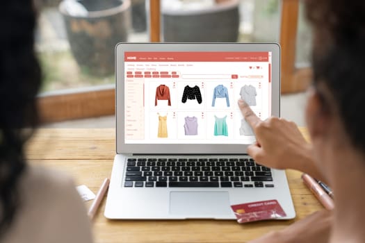 Woman shopping online on internet marketplace browsing for sale items for modern lifestyle and use credit card for online payment from wallet protected by crucial cyber security software