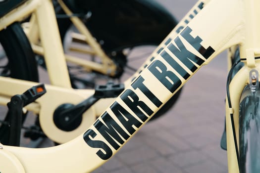 A detailed shot of a sleek bicycle parked on a sidewalk, showcasing its advanced features like a crankset, rim, and bicycle tire