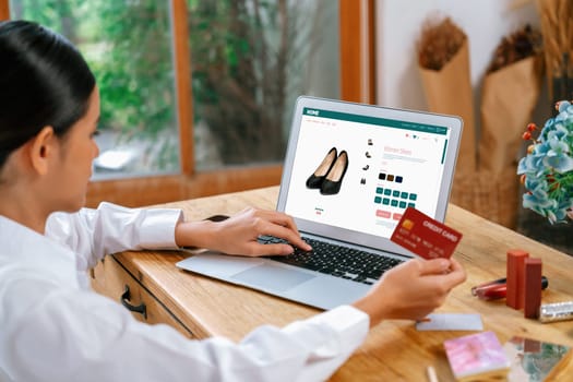 Woman shopping online on internet marketplace browsing for sale items for modern lifestyle and use credit card for online payment from wallet protected by uttermost cyber security software