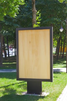 A wooden billboard stands in the park,