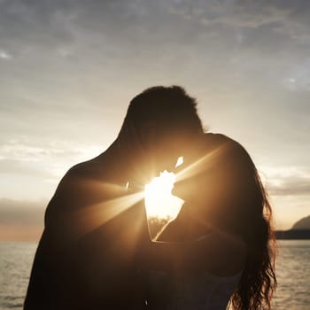 Silhouette, couple and face at ocean for sunset, vacation or travel together in summer on lens flare. Man, woman and romance at sea with shadow for connection, love and adventure by water outdoor.