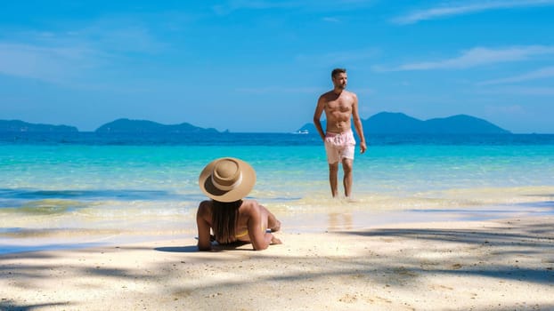 Koh Wai Island Trat Thailand is a tinny tropical Island near Koh Chang. a young couple of men and women on a tropical beach lying down sunbathing during a luxury vacation in Thailand