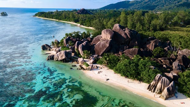 Drone top view at Anse Source d'Argent beach La Digue Island Seychelles, Drone aerial view of La Digue Seychelles, tropical vacation summer holiday, a beach with huge granite rocks at sunset