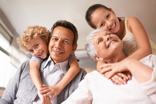 Portrait, grandparents and grandchildren with smile for family, photo and multi generation bonding. Senior couple, boy and girl with hug, love and happiness for playful relationship together at home.