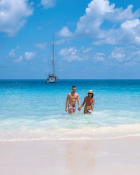 young couple of men and women on a tropical ocean beach during a luxury vacation in Seychelles. Tropical beach Anse Lazio Praslin Seychelles, diverse couple of men and women on vacation summer holiday