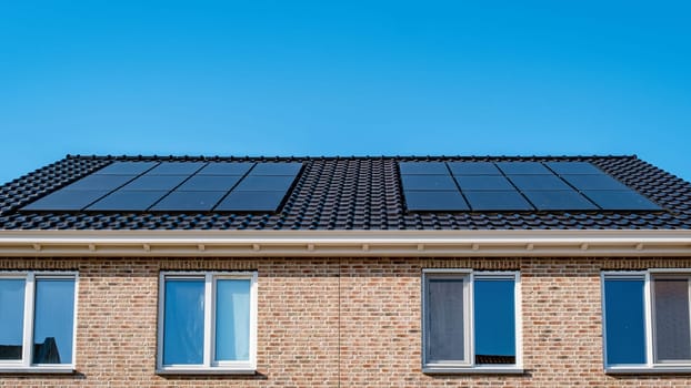 A rectangular building with solar panels on the roof in a residential area. The blue sky and azure fixtures complement the siding