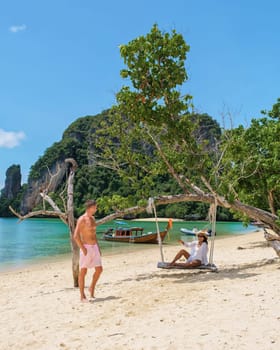 Young Asian women and European men on the beach during a vacation in Thailand. a diverse couple on a tropical holiday island hopping in Thailand, Koh Phakbia Island is near Koh Hong Krabi in Thailand