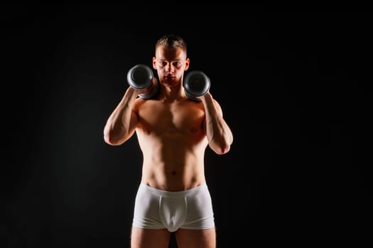 Dumbbells, fitness and man in a studio for training, exercise or bodybuilding studio shot.