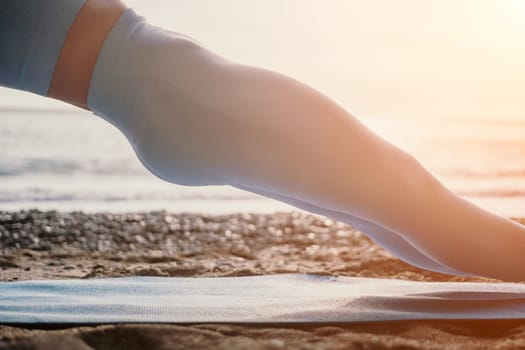 Middle aged well looking woman with black hair doing Pilates with the ring on the yoga mat near the sea on the pebble beach. Female fitness yoga concept. Healthy lifestyle, harmony and meditation.