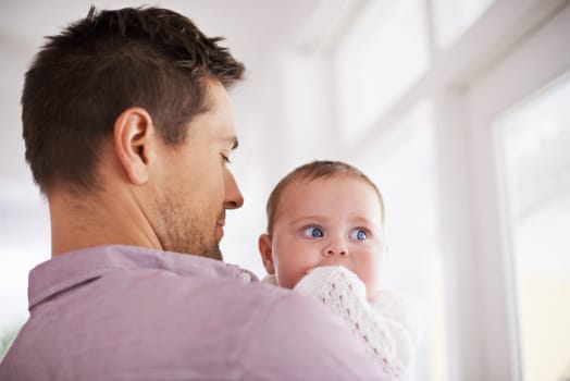 Father, baby and home with love, parent and bonding together with newborn and kid. Caring, family and dad with young child in a living room with support and care in a house carrying a calm infant.